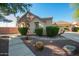 Charming home featuring a stone facade, manicured bushes, and a well-maintained yard at 15272 W Georgia Dr, Surprise, AZ 85379