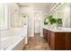 Luxurious bathroom features a soaking tub, glass-enclosed shower, and dual vanities at 15272 W Georgia Dr, Surprise, AZ 85379