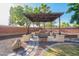 Inviting outdoor pergola featuring stone benches, a brick accent wall, and ambient string lights at 15272 W Georgia Dr, Surprise, AZ 85379