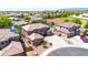 Aerial view showcases a two-story home with a pool, sports fields, and mountain views in the distance at 15725 W Yucatan Dr, Surprise, AZ 85379