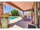 Beautiful backyard with a sparkling pool, covered patio, lush greenery, and outdoor seating at 15725 W Yucatan Dr, Surprise, AZ 85379
