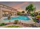 Relaxing backyard retreat with a gorgeous pool, covered patio, and vibrant flowers, creating a tranquil oasis at 15725 W Yucatan Dr, Surprise, AZ 85379