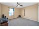 Neutral bedroom with ceiling fan features workout equipment and a window at 15725 W Yucatan Dr, Surprise, AZ 85379