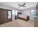 Neutral bedroom showcases a dark dresser with mirror, ceiling fan and a window at 15725 W Yucatan Dr, Surprise, AZ 85379