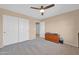 Large bedroom with double door closet, ceiling fan, neutral carpet, and ensuite entrance at 15725 W Yucatan Dr, Surprise, AZ 85379