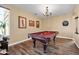 A game room featuring a pool table, chandelier lighting, wood flooring, and neutral color palette at 15725 W Yucatan Dr, Surprise, AZ 85379