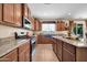 Open kitchen with granite countertops, wooden cabinets, a blue sink, and stainless steel appliances at 15725 W Yucatan Dr, Surprise, AZ 85379