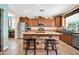 A kitchen featuring an island with seating, stainless appliances, ample cabinets, and lots of natural light at 15725 W Yucatan Dr, Surprise, AZ 85379