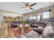 Bright living room with a leather sectional and a view of the kitchen with lots of cabinetry at 15725 W Yucatan Dr, Surprise, AZ 85379