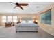 Bright main bedroom with a plush bed, ceiling fan and lots of natural light at 15725 W Yucatan Dr, Surprise, AZ 85379