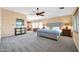 Expansive main bedroom with large windows, ceiling fan, sitting area and comfortable carpet at 15725 W Yucatan Dr, Surprise, AZ 85379