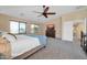Spacious main bedroom featuring soft carpet, a ceiling fan, and large windows at 15725 W Yucatan Dr, Surprise, AZ 85379