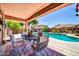 Inviting pool area with outdoor dining under a covered patio, perfect for relaxing and entertaining at 15725 W Yucatan Dr, Surprise, AZ 85379