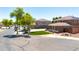 View of the home's side exterior near a basketball court, with grass and trees along the street at 15725 W Yucatan Dr, Surprise, AZ 85379