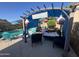 Inviting backyard with a covered patio lounge, offering comfortable seating and scenic views of the refreshing pool area at 15939 W Post Dr, Surprise, AZ 85374