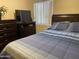 Bedroom featuring a wooden bed frame, a TV, and a window with blinds at 15939 W Post Dr, Surprise, AZ 85374