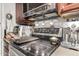 Kitchen cooktop and oven with stainless steel appliances and dark wood cabinets at 1618 N 32Nd St # 5, Phoenix, AZ 85008