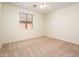 Bright bedroom with tan carpet, a ceiling fan, and a large window at 16515 N 71St Dr, Peoria, AZ 85382