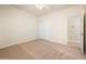 Bedroom featuring tan carpet, ceiling fan, closet, and view into an ensuite at 16515 N 71St Dr, Peoria, AZ 85382
