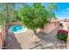 View of a private pool with well maintained landscaping and a tree in the yard at 16515 N 71St Dr, Peoria, AZ 85382