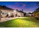 Expansive backyard with a covered patio, lush lawn, and cozy seating area at 1934 E Cypress Tree Dr, Gilbert, AZ 85234