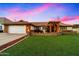 Charming brick home featuring a lush lawn, arched entryway and white garage door at 1934 E Cypress Tree Dr, Gilbert, AZ 85234