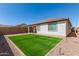 The outdoor living space features artificial grass, a covered patio, and a low-maintenance landscape at 19627 W Badgett Ln, Litchfield Park, AZ 85340