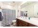 Bathroom features a dark wooden vanity, white countertops, and a shower with a striped curtain at 19627 W Badgett Ln, Litchfield Park, AZ 85340
