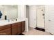 Bathroom showcasing a large vanity with double sinks, wood floors, and glass enclosed shower at 19627 W Badgett Ln, Litchfield Park, AZ 85340
