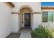Close-up of an arched front entryway with a modern black door and well-maintained landscaping at 19627 W Badgett Ln, Litchfield Park, AZ 85340