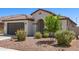 Charming home showcasing desert landscaping, an arched entry, and a gray garage door at 19627 W Badgett Ln, Litchfield Park, AZ 85340
