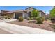 Charming home showcasing desert landscaping, an arched entry, and a gray garage door at 19627 W Badgett Ln, Litchfield Park, AZ 85340