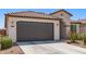 Attractive garage door detail of a single-story home with a tiled roof and desert-style landscaping at 19627 W Badgett Ln, Litchfield Park, AZ 85340