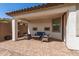 A covered patio offers an outdoor living space complete with a sitting area and tile flooring at 19627 W Badgett Ln, Litchfield Park, AZ 85340