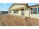 Close up of the front entrance with a covered porch, brown door, and desert landscaping at 22375 S Manzanilla Rd, Buckeye, AZ 85326