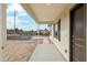Covered front porch with decorative columns, textured walls, and a dark brown front door at 22375 S Manzanilla Rd, Buckeye, AZ 85326