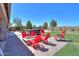 Inviting backyard with red Adirondack chairs around a fire pit and a pool with a hot tub at 226 W Crimson Sky Ct, Casa Grande, AZ 85122