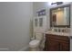 Well-lit bathroom with a dark wood vanity, granite countertop, and a toilet with cabinet storage at 226 W Crimson Sky Ct, Casa Grande, AZ 85122