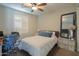 Cozy bedroom featuring a ceiling fan, bright windows with shutters, and a comfortable bed at 226 W Crimson Sky Ct, Casa Grande, AZ 85122