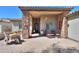 Covered front porch with stone columns, desert landscaping, and outdoor seating at 226 W Crimson Sky Ct, Casa Grande, AZ 85122