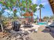 Backyard oasis featuring a swimming pool, patio seating, palm trees, and gravel landscaping at 230 S 122Nd Ln, Avondale, AZ 85323