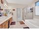 Bathroom featuring double sinks, a shower with a glass enclosure, a soaking tub, and neutral decor at 230 S 122Nd Ln, Avondale, AZ 85323