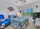 Bright bedroom featuring white walls, ceiling fan, and a comfortable bed with blue and yellow patterned bedding at 230 S 122Nd Ln, Avondale, AZ 85323