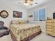 Cozy bedroom with a patterned bedspread, chair and shuttered window at 230 S 122Nd Ln, Avondale, AZ 85323