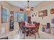 Cozy dining room with a round wooden table, seating for eight, and a decorative ceiling fan at 230 S 122Nd Ln, Avondale, AZ 85323