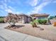 Attractive single-story home with desert landscaping, and a pink flowering tree in front at 230 S 122Nd Ln, Avondale, AZ 85323