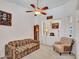 Well-lit living room with carpeted floors, a ceiling fan, and comfortable seating at 230 S 122Nd Ln, Avondale, AZ 85323