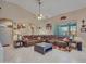 Spacious living room with a large brown leather sectional sofa, tile flooring, and a ceiling fan at 230 S 122Nd Ln, Avondale, AZ 85323