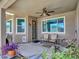 Covered patio featuring a ceiling fan, tiled flooring, patio furniture, and a security door at 230 S 122Nd Ln, Avondale, AZ 85323