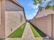 Clean side yard with artificial turf, a paved walkway, and privacy fencing, offering a low-maintenance outdoor space at 230 S 122Nd Ln, Avondale, AZ 85323